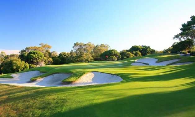 Bunkers guarding a green under a clear sky